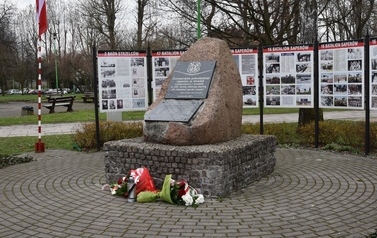 Na znajduje się pomnik z tablicą z nazwiskami saper&oacute;w, kt&oacute;rzy zginęli podczas odminowywania teren&oacute;w kociewskich po zakończeniu II Wojny Światowej, w tle są witryny informacyjne oraz maszt z flagą Polski.